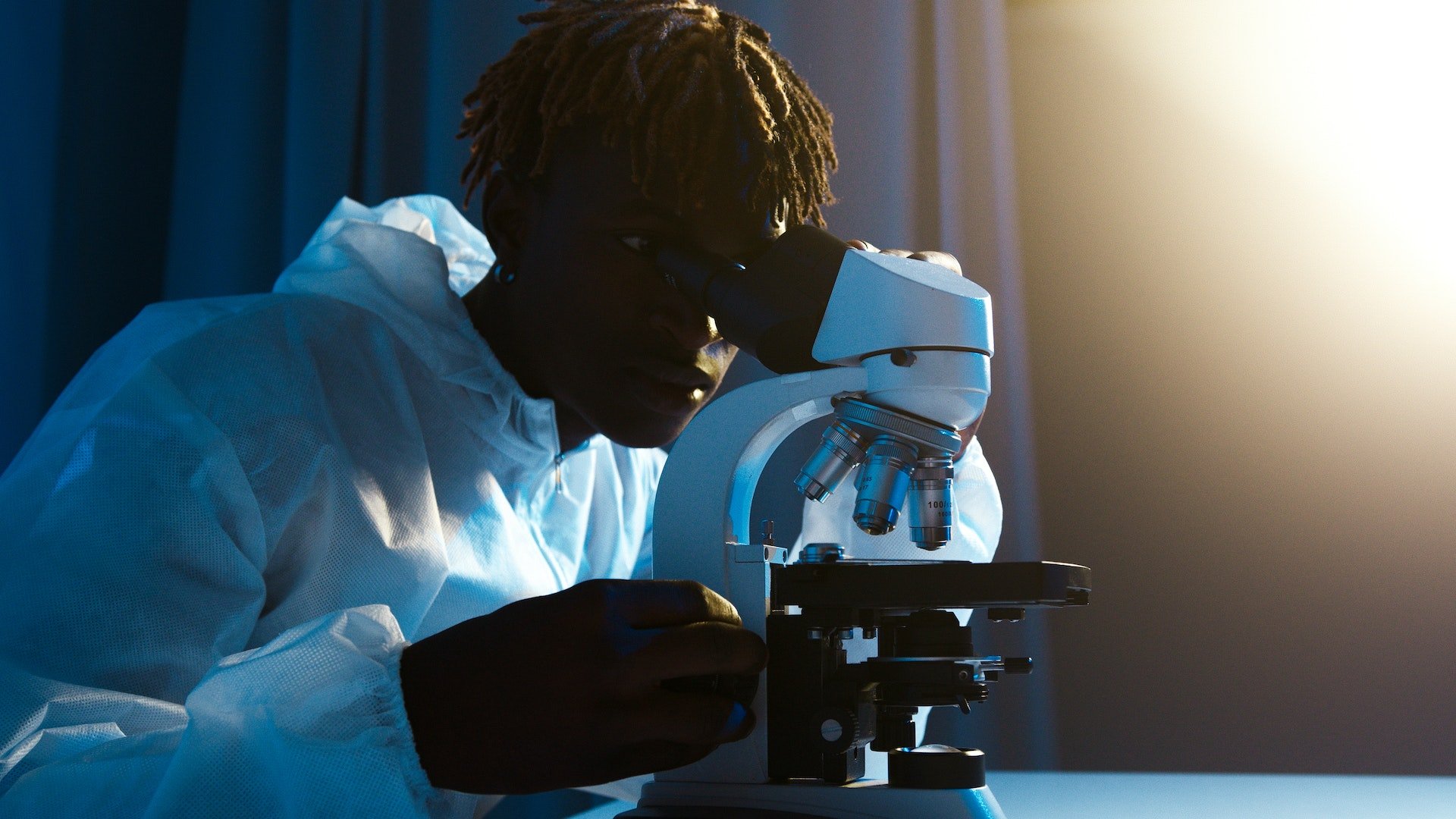 scientist looking at microscope