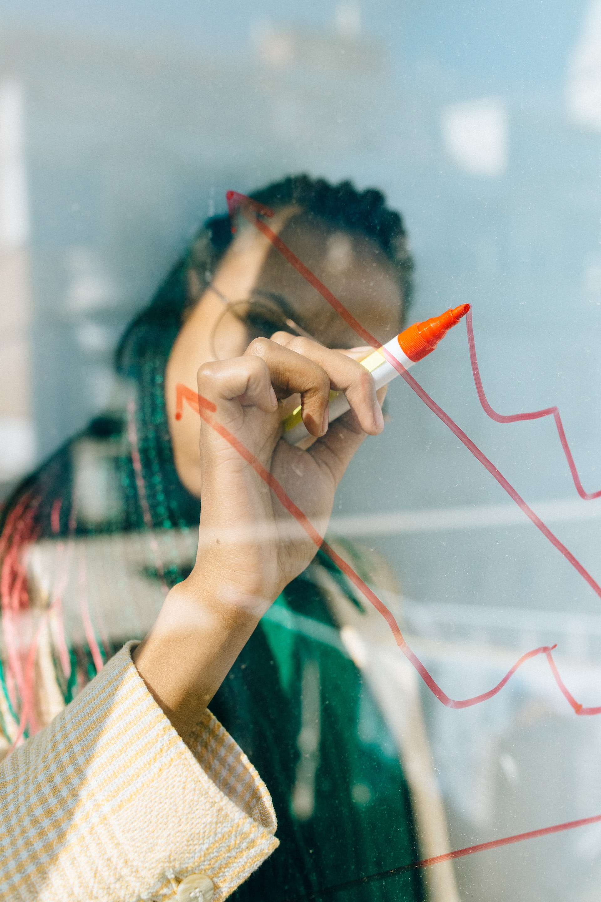 woman writing on transparent whiteboard brainstorming master data management ideas for the banking industry